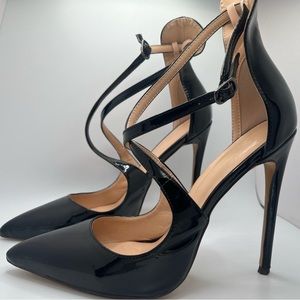 Black strappy 4 1/2 inch high heeled patent leather pumps.